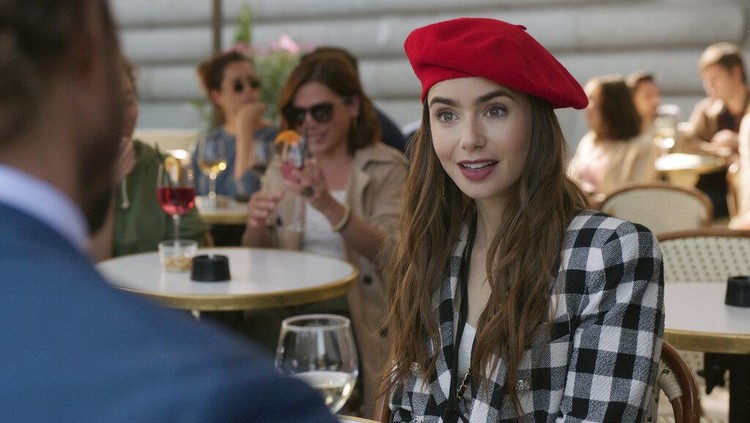 Lily Collins di Emily in Paris This image released by Netflix shows William Abadie, left, and Lily Collins in a scene from the series