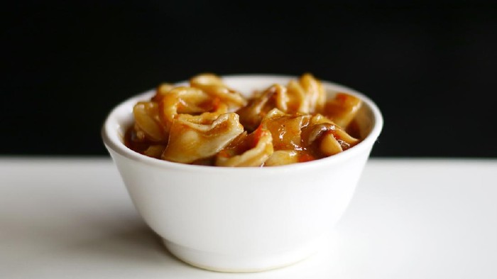 Cumi Saus Padang or Squid in Padang Sauce on black background. Spicy food from Padang, West Sumatra, Indonesia.