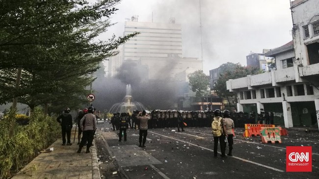 Massa terus melempari petugas dengan botol mineral, botol kaca, kayu dan petasan.