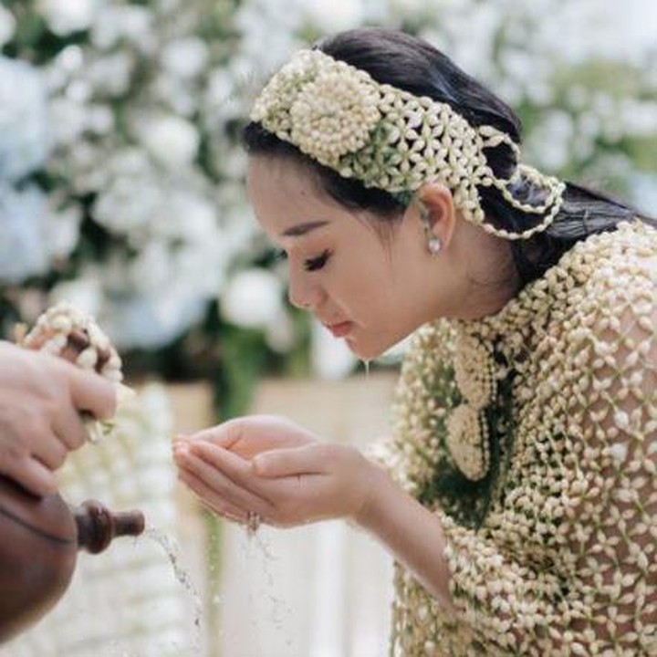 <p>Menjalani rangkaian prosesi 7 bulanan, Zaskia Gotik mengenakan roncean bunga melati dan menadahi air yang mengalir dari kendi. (Foto: Instagram @frrdnnn)</p>