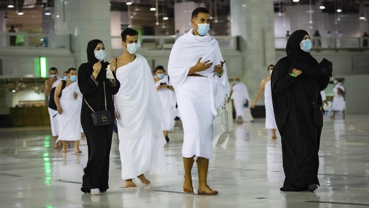 CLARIFIES THAT THE UMRAH PILGRIMAGE CAN BE UNDERTAKEN AT ANY TIME OF THE YEAR -- In this photo released by Saudi Ministry of Hajj and Umrah, Muslims practice social distancing while praying around the Kaaba, the cubic building at the Grand Mosque during the first day umrah pilgrimages were allowed to restart, in the Muslim holy city of Mecca, Saudi Arabia, Sunday, Oct. 4, 2020. The umrah pilgrimage, or smaller pilgrimage, can be undertaken at any time of the year. A very small, limited number of people donning the white terrycloth garment symbolic of the Muslim pilgrimage circled Islam's holiest site in Mecca on Sunday after Saudi Arabia lifted coronavirus restrictions that had been in place for months. (Saudi Ministry of Hajj and Umrah via AP)