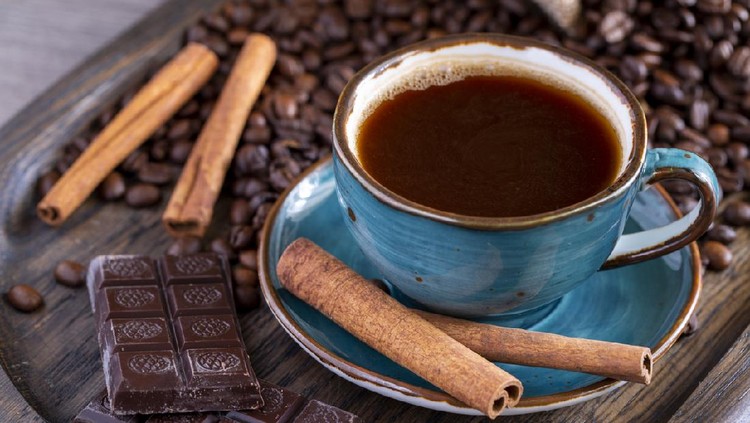 A cup of coffee, chocolate, cinnamon, coffee beans on a wooden tray. Life style. High quality photo