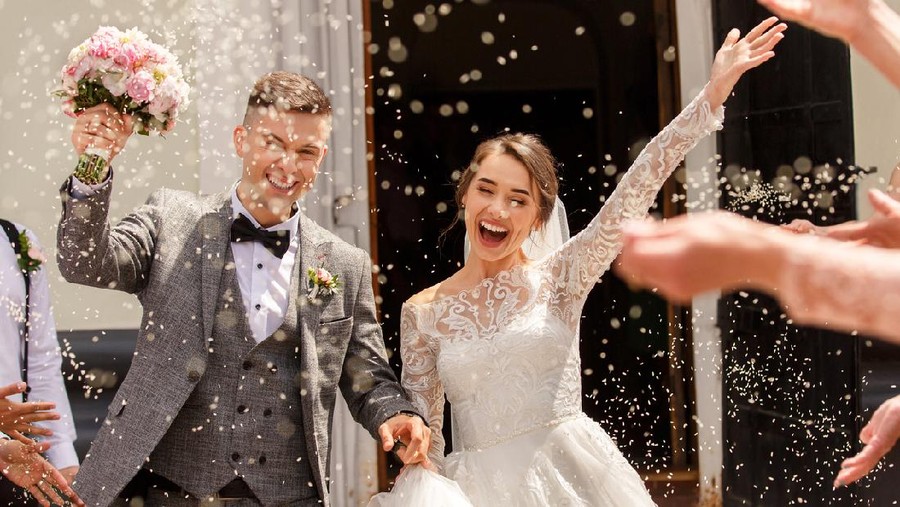 Happy wedding photography of bride and groom at wedding ceremony. Wedding tradition sprinkled with rice and grain