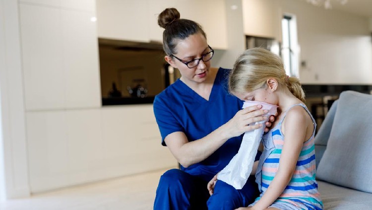 Home Call Nurse Using Sick Bag With Child in Australian house