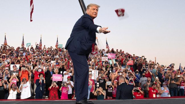 Kampanye Usai Negatif Covid, Trump Lempar Masker ke Pendukung Donald Trump melemparkan masker ke arah pendukung saat kampanye perdana usai dinyatakan negatif Covid-19 di Florida.