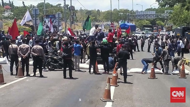 Mahasiswa memblokade jembatan Suramadu saat berunjuk rasa menolak Omnibus Law, Selasa (12/10).