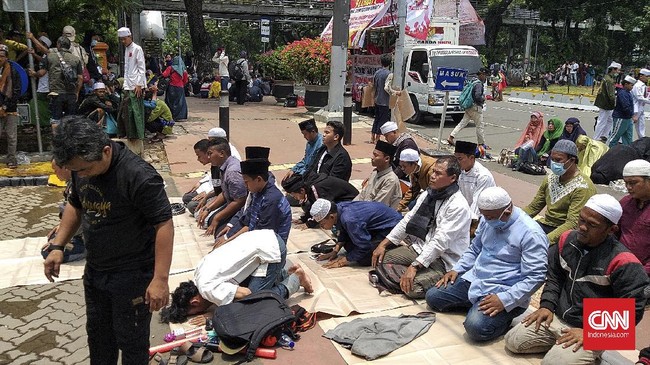 Massa aksi 13 Oktober menolak Omnibus Law UU Ciptaker menggelar salat berjamaah di trotoar jalan.
