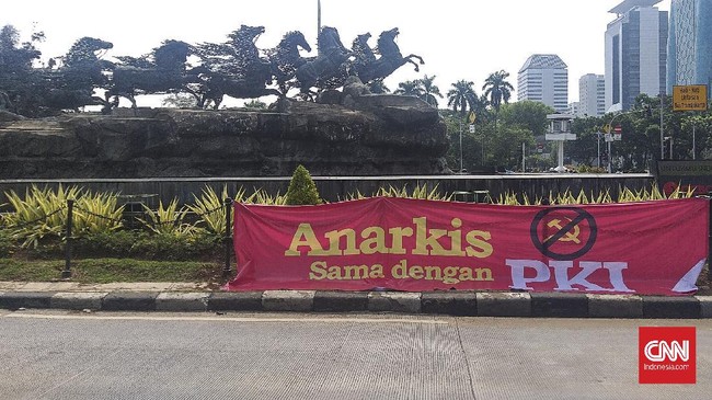 Spanduk bertuliskan 'Anarkis Sama dengan PKI' terpasang di Patung Kuda jelang aksi unjuk rasa tolak UU Ciptaker yang diinisiasi aliansi PA 212 dkk hari ini.