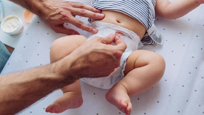 Father change diaper to baby boy on baby changing table