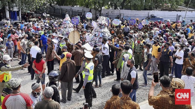 Warga di Pasar Klewer Timur berebut gunungan sambil berdesakkan di acara Boyongan yang digelar Pemkot Solo, Jumat (16/10).