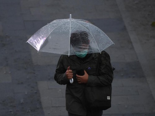 Seorang warga membawa payung saat melintas di Kawasan Senayan, Jakarta, Jumat (16/10/2020). Menurut Badan Meteorologi, Klimatologi dan Geofisika (BMKG) musim hujan di Indonesia telah berlangsung dari bulan Oktober dan diprediksi puncak musim hujan te