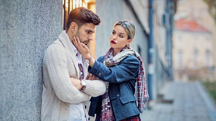 Woman is consoling her sulking boyfriend on the street