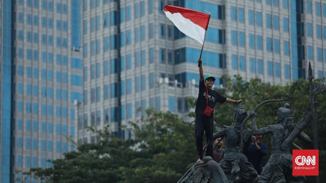 Suasana mendadak gegap gempita usai 3 orang memasang bendera merah putih di atas patung kuda, Jalan Medan Merdeka, Barat, Jakarta.
