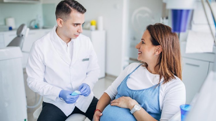 Man and woman, man dentist with a pregnant woman patient in ordination.