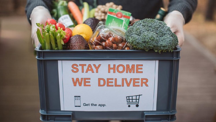 Delivering food ordered online while in home isolation during quarantine. Stay home we deliver sign on box.