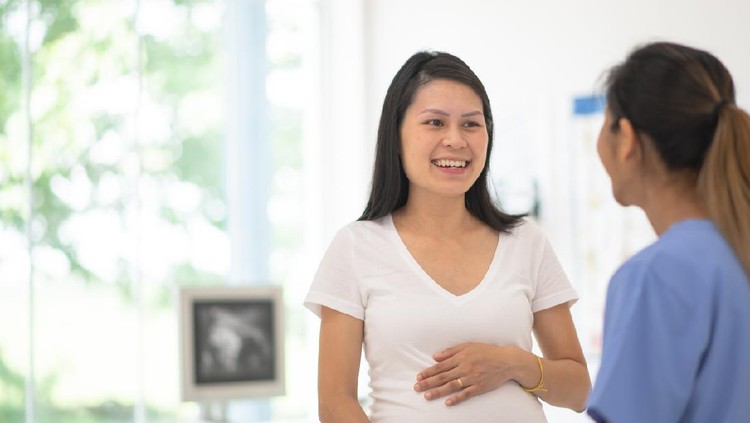 A woman discuses her prenatal health during a routine check up with her obstetrician