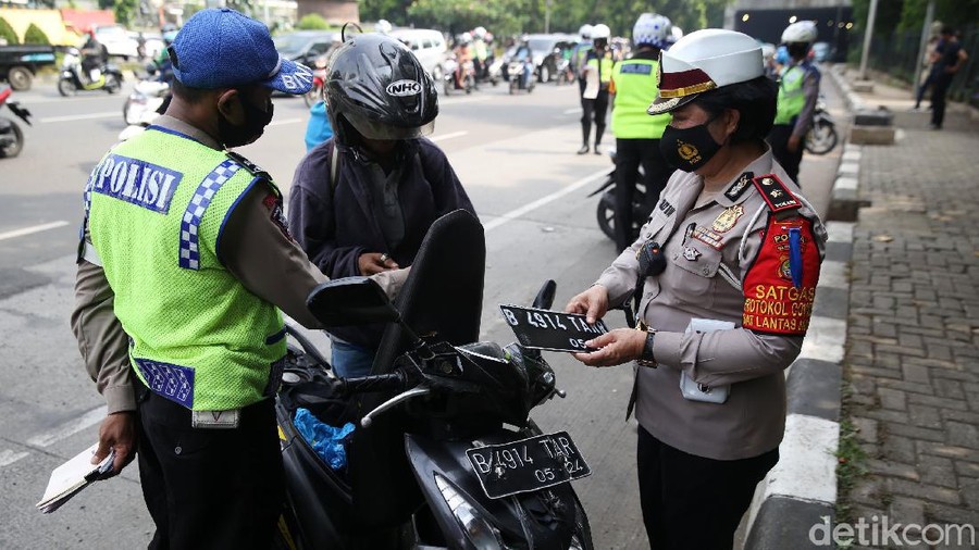 Anggota Polisi Satua Lalu Lintas Polres Jakarta Timur melakukan razia kendaraan bermotor di Jalan DI Panjaitan, Cawang, Jakarta Timur, Senin (26/10/2020). Operasi Zebra 2020 mulai digelar Senin (26/10). Ada lima jenis pelanggaran yang menjadi prioritas sasaran penindakan dalam operasi yang akan berlangsung hingga 8 November mendatang.