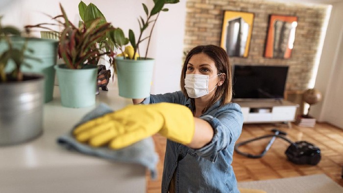 Woman working at home, cleaning the floors, washing the laundry and cleaning up the mess in the closet during quarantine