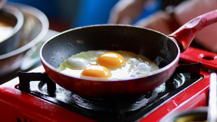 Cooking Eggs Sunny-side-up in a non-stick pan on a gas stove. Frying a batch of eggs for breakfast in a non-stick pan with a gas stove.