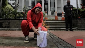FOTO: 'Salvador Dali' Bakar Salinan UU Ciptaker di Depan MK