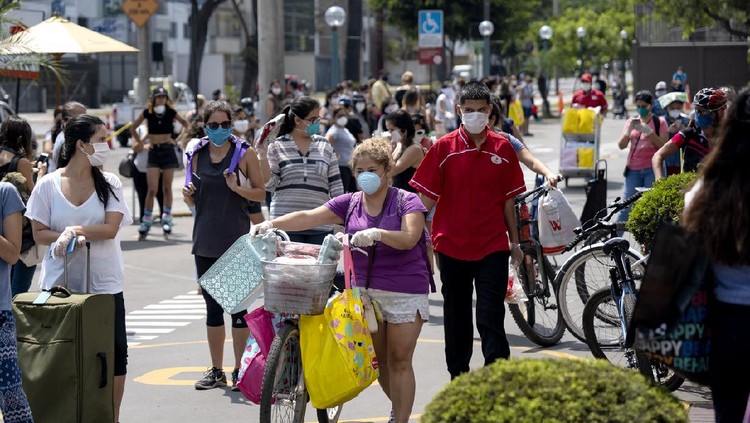 Lima, Peru - April 4 2020: Woman with bike and groceries wearing mask amid coronavirus outbreak in South America. Only woman day, gender-based quarantine, women lined up to buy groceries.