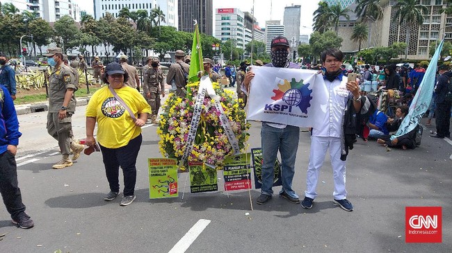 Dalam aksi demo menolak Omnibus Law Ciptaker, buruh memajang karangan bunga duka cita atas kematian nurani wakil rakyat dan penguasa.