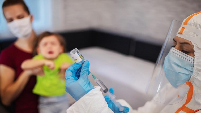Pediatrician makes vaccination to small girl