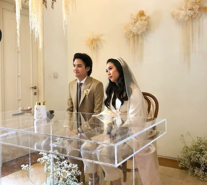 Sherina Munaf telah resmi menikah dengan sang kekasih, Baskara Mahendra, pada 3 November 2020 kemarin. Selain pernikahannya yang digelar secara tiba-tiba dan tertutup hanya dihadiri oleh 10 orang, busana pernikahan Sherina pun turut menjadi sorotan. Sebagai mempelai, Sherina tampil formal menggunakan suit blazer dan celana. Rambutnya yang panjang dibiarkan tergerai indah dengan dihiasi headpiece serta tudung. So edgy! (Pernikahan Sherina/Foto: Instagram/teamsherina)