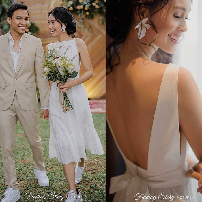 Presenter Conchita Caroline memilih wedding dress berdesain simple pada pesta pernikahannya. Alasannya, dirinya dan suami hanya ingin menjadi diri sendiri di hari bahagia keduanya. Conchita terlihat manis menggunakan gaun sederhana berwana putih dengan potongan punggung yang rendah. Ia juga memakai anting berbentuk bunga dan sepatu sneakers berwarna senada. (Pernikahan Conchita Caroline/Foto: Instagram/conchizzlin)