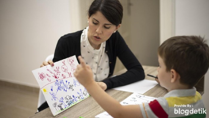 Five years old boy drawing at the psychotherapy session.