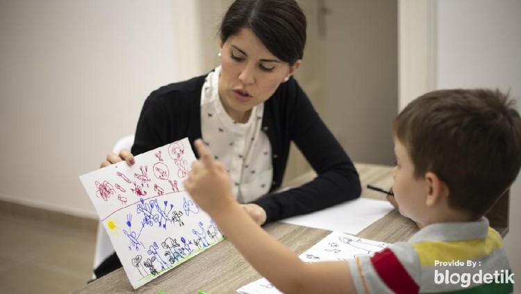 Five years old boy drawing at the psychotherapy session.