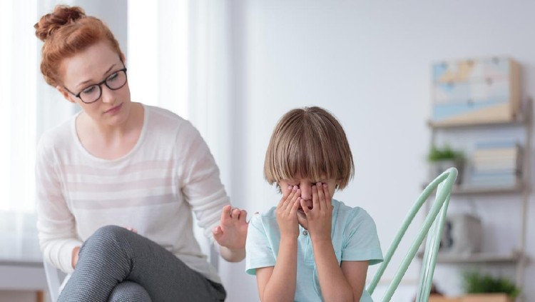 Parenthood and child development, young worried mother comforting little son crying at home