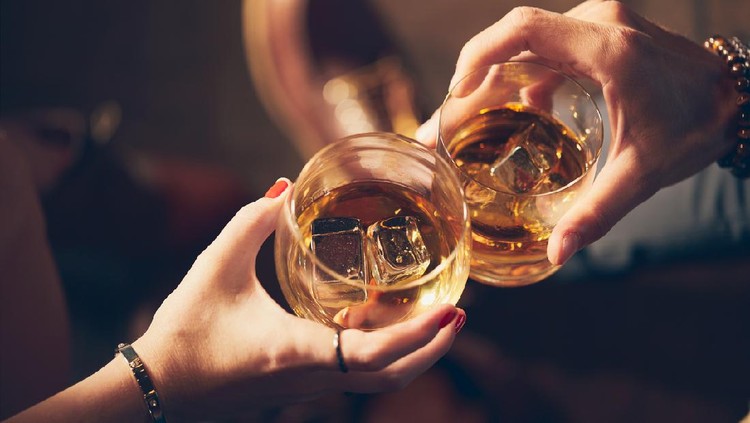 Minuman beralkohol A couple makes a toast with two glasses of whiskey