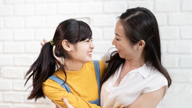 Happy Asian family Mom and teenage daughter embrace together excited, glad in a room that has sunlight from the window at home. Show Love family concept