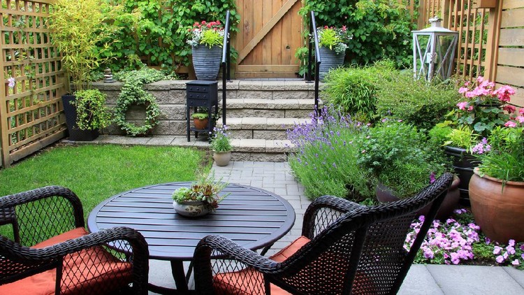 Small townhouse garden with patio furniture amidst blooming lavender.