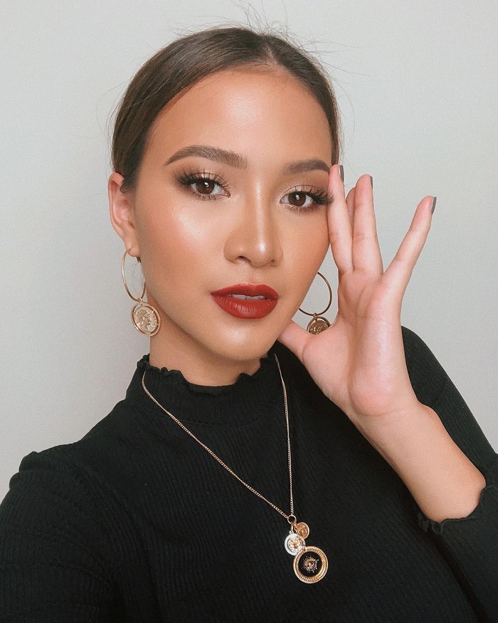 Beauty influencer Sara Robert tampil simpel namun elegan dengan lipstik berwarna merah. Ia memadukan polesan lipstik-nya dengan riasan smokey eyes bernuansa bronze serta tampilan complexion yang glowing. Dengan mengenakan outfit hitam, Sara lalu menambahkan perhiasan anting dan kalung gold yang membuat penampilannya tampak semakin classy. (Foto: instagram.com/sararobert)