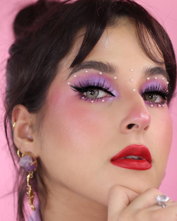 Terakhir, ada Tasya Farasya yang tampil playful dengan memadukan riasan mata lilac dan lipstik merah. Ia juga menambahkan hiasan manik-manik di bawah alis dan mata serta tulang hidung yang membuat gaya makeup-nya semakin tampak seru. Berani coba, Ladies? (Foto: instagram.com/tasyafarasya)