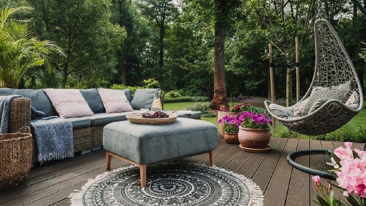 Garden patio decorated with Scandinavian wicker sofa and coffee table