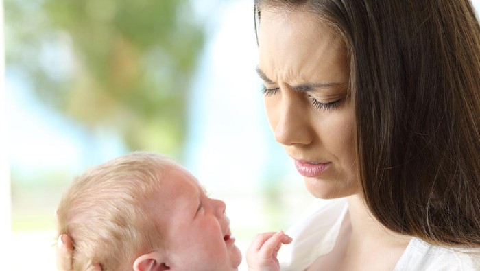 Tired desperate mother and baby crying