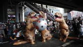 FOTO: Kala Dinosaurus Ikut Demo di Thailand Demonstran kenakan kostum dinosaurus saat aksi protes pro-demokrasi di Thailand, Sabtu (21/11).