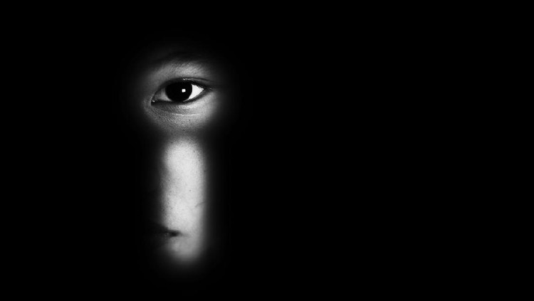 eye of boy through key whole, child abuse concept
