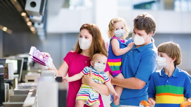 Family in airport in face mask. Virus outbreak. Coronavirus and flu pandemic. Safe travel with young child and baby. Mother, father and kids boarding airplane in surgical masks.