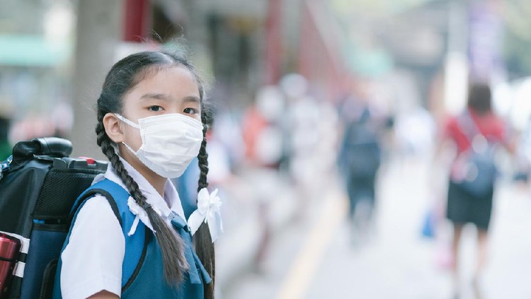 Anak sekolah pakai masker School Girl wearing mouth mask against air smog pollution in Bangkok city, Thailand