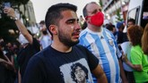 FOTO: Tangis Argentina atas Kematian Maradona Masyarakat Argentina meluapkan duka ke jalanan menyusul kematian legenda sepak bola Diego Maradona, Rabu (25/11).