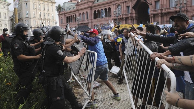 Kericuhan terjadi antara ratusan fan Diego Maradona dengan polisi di luar Istana Presiden Argentina. Ratusan fan berebut melihat peti mati Maradona.
