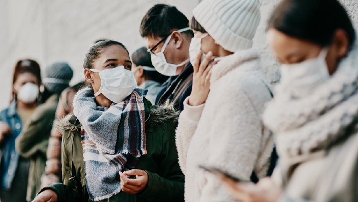 Shot of a young man and woman wearing masks while travelling in a foreign city