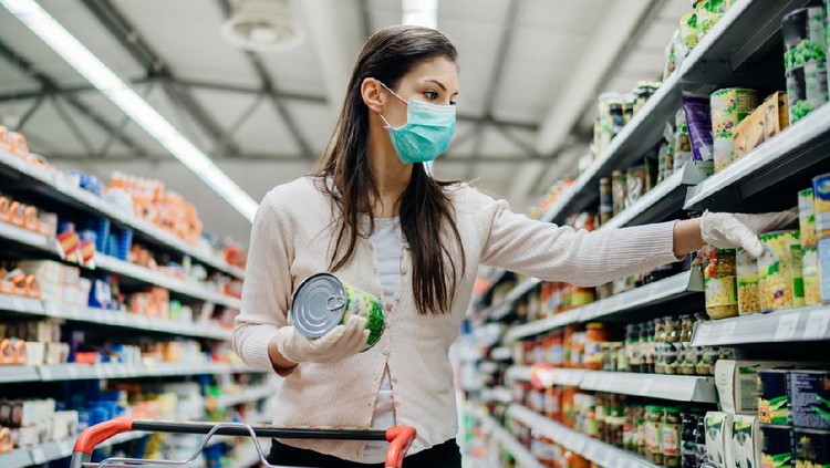 Woman preparing for pathogen virus pandemic spread quarantine.Choosing nonperishable food essentials.Budget buying at a supply store.Pandemic quarantine preparation.Emergency to buy list