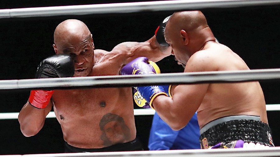 APTOPIX Tyson Jones Boxing In a photo provided by Triller, Mike Tyson throws a punch during the third round against Roy Jones Jr. in an exhibition boxing bout Saturday, Nov. 28, 2020, in Los Angeles. The bout was unofficially ruled a draw by the WBC judges at ringside. Tyson and Jones fought eight two-minute rounds, and both emerged smiling and apparently healthy from a highly unusual event. (Joe Scarnici/Triller via AP)