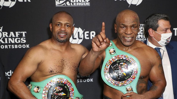 In a photo provided by Triller, Mike Tyson throws a punch during the fourth round against Roy Jones Jr. in an exhibition boxing bout Saturday, Nov. 28, 2020, in Los Angeles. The bout was unofficially ruled a draw by the WBC judges at ringside. Tyson and Jones fought eight two-minute rounds, and both emerged smiling and apparently healthy from a highly unusual event. (Joe Scarnici/Triller via AP)