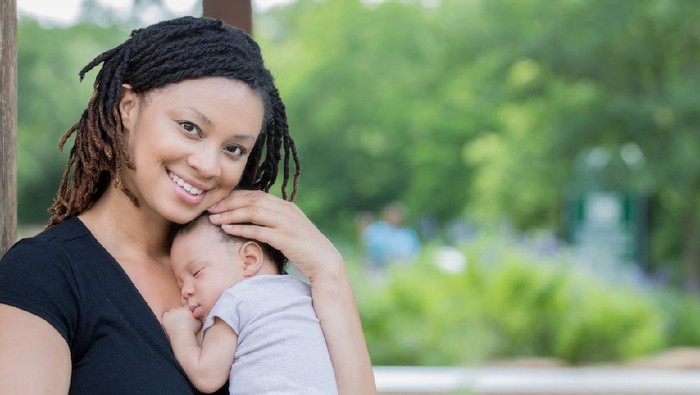 Mom smiles while holding new baby